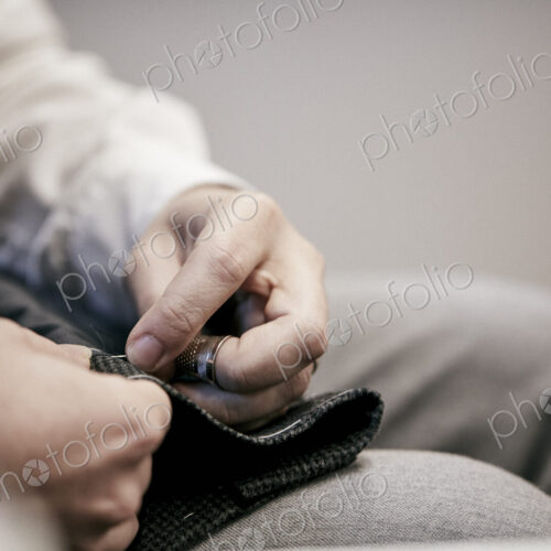Man's hand sewing using needle and thread Man's hand sewing using needle and thread