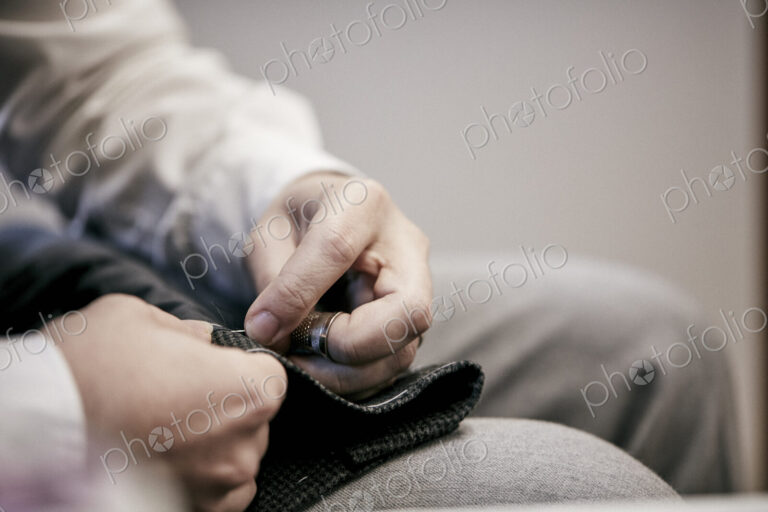 Man's hand sewing using needle and thread