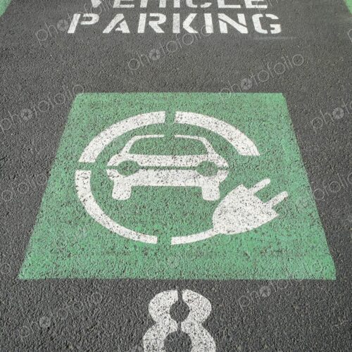 Marked parking space reserved for electric vehicles with green EV symbol and charging… Marked parking space reserved for electric vehicles with green EV symbol and charging…