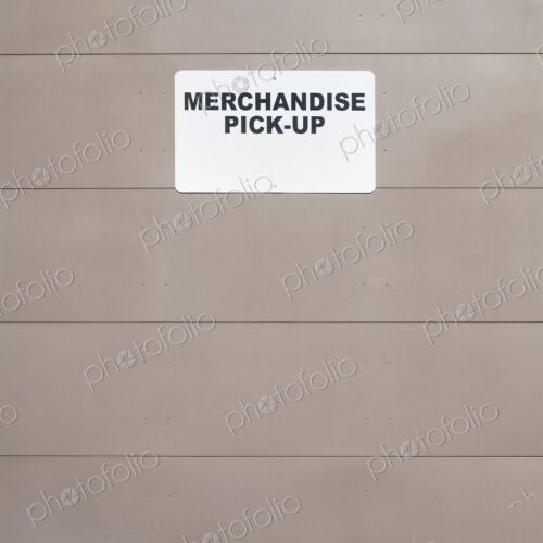 Merchandise Pick-up sign on metal loading dock door, Washington, USA