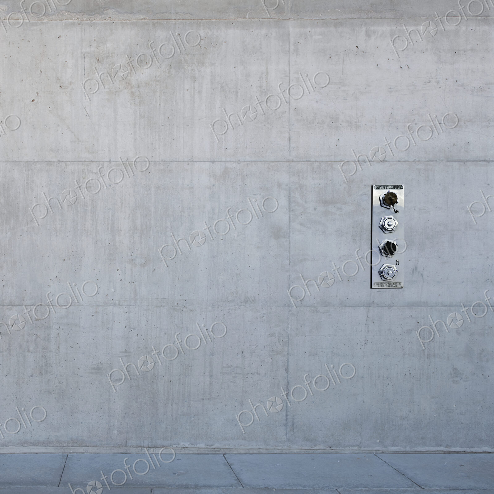 Metal control panel on concrete wall.