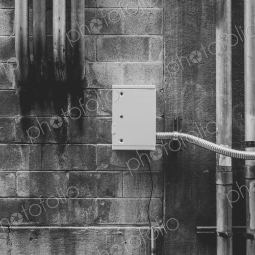 Metal electrical piping on building wall Metal electrical piping on building wall