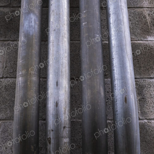 Metal piping against building wall