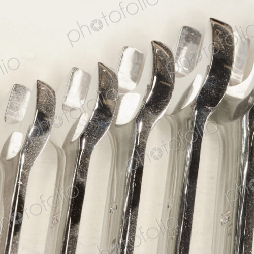 Metal spanners lined up in size order with dust. Metal spanners lined up in size order with dust.
