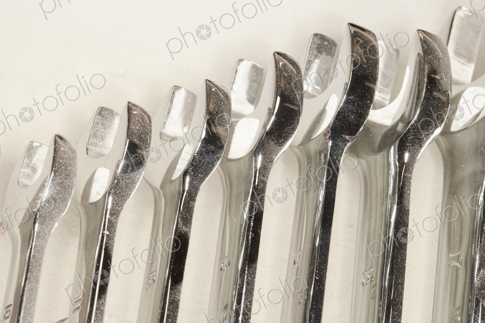 Metal spanners lined up in size order with dust.