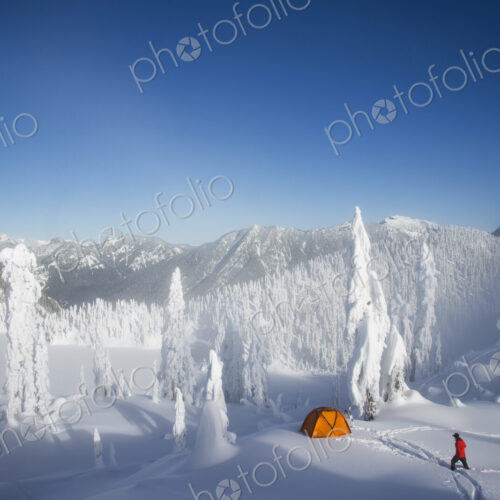 Michael Hanson walks through deep powder to his campsite in the snow covered Cascade…