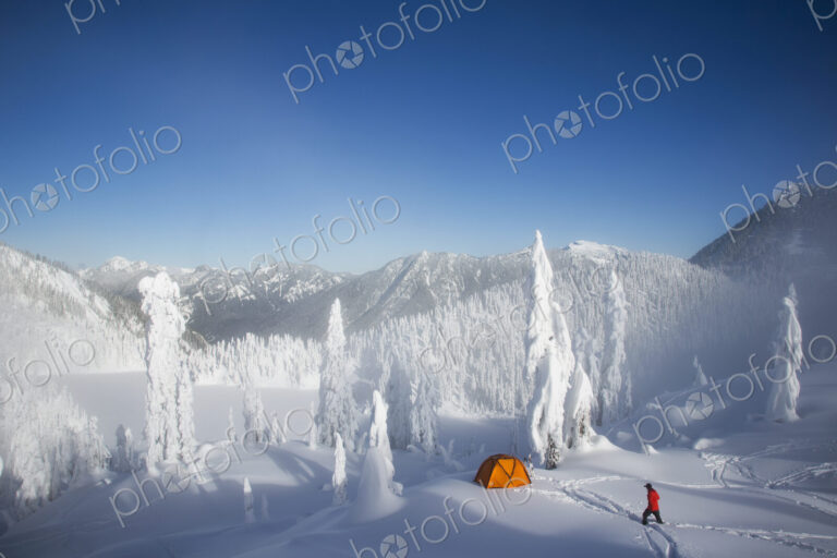 Michael Hanson walks through deep powder to his campsite in the snow covered Cascade…