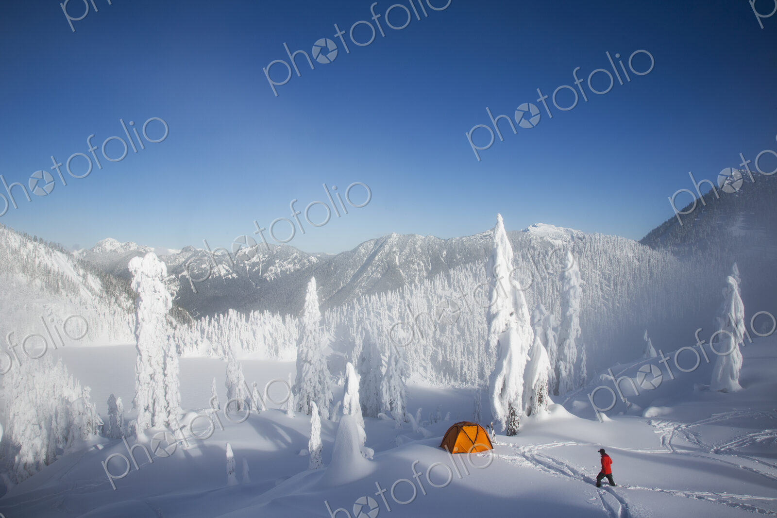 Michael Hanson walks through deep powder to his campsite in the snow covered Cascade…