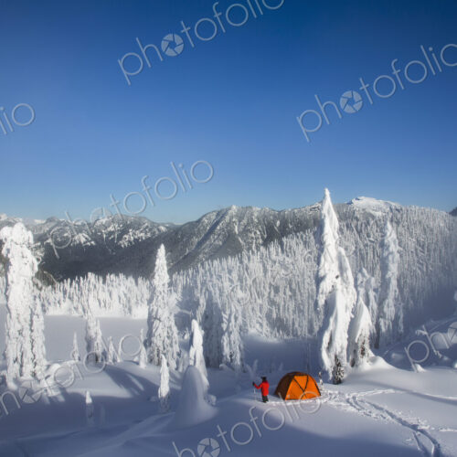 Michael Hanson walks through deep powder to his campsite in the snow covered Cascade…