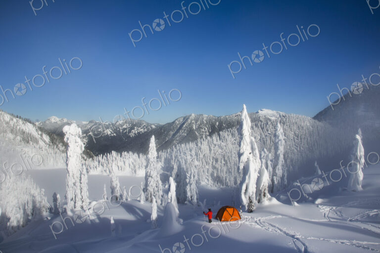 Michael Hanson walks through deep powder to his campsite in the snow covered Cascade…