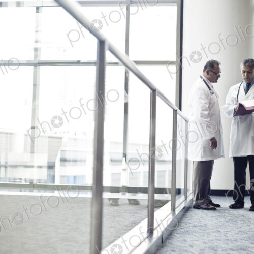Middle Eastern and black male doctors conferring on on medical case.