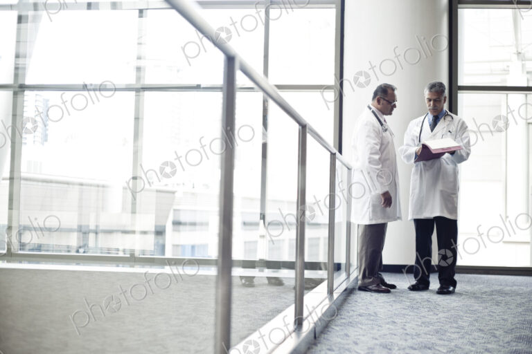 Middle Eastern and black male doctors conferring on on medical case.