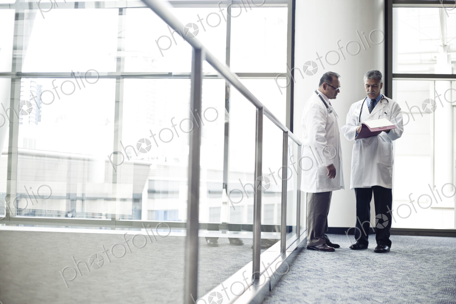 Middle Eastern and black male doctors conferring on on medical case.