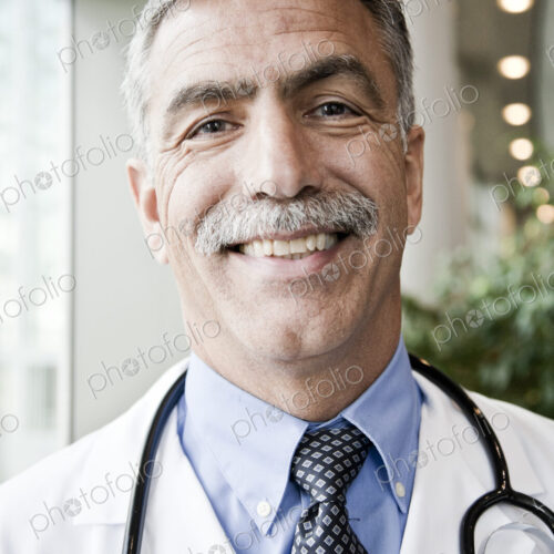 Middle Eastern man doctor in lab coat with stethoscope.