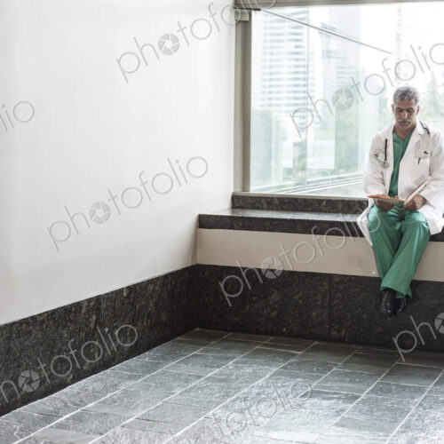 Middle Eastern man doctor texting on a cell phone.