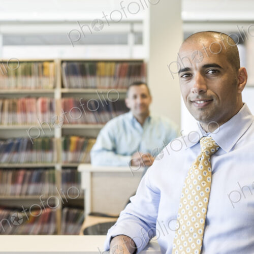 Middle eastern male dentist in his office with patient file folders in the background. Middle eastern male dentist in his office with patient file folders in the background.