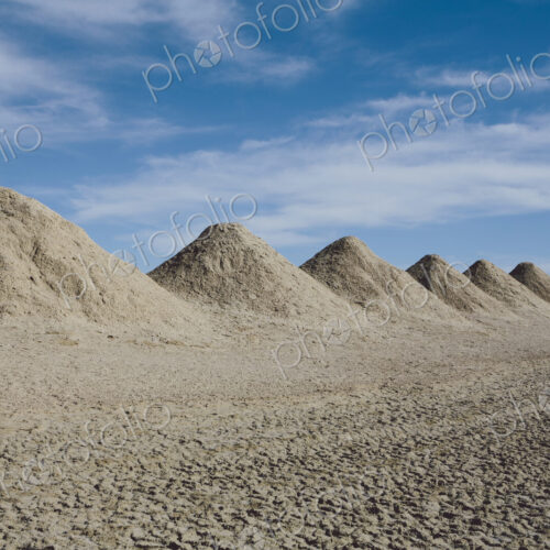 Mining tailings creating row of dirt piles in a desert, extraction Mining tailings creating row of dirt piles in a desert, extraction