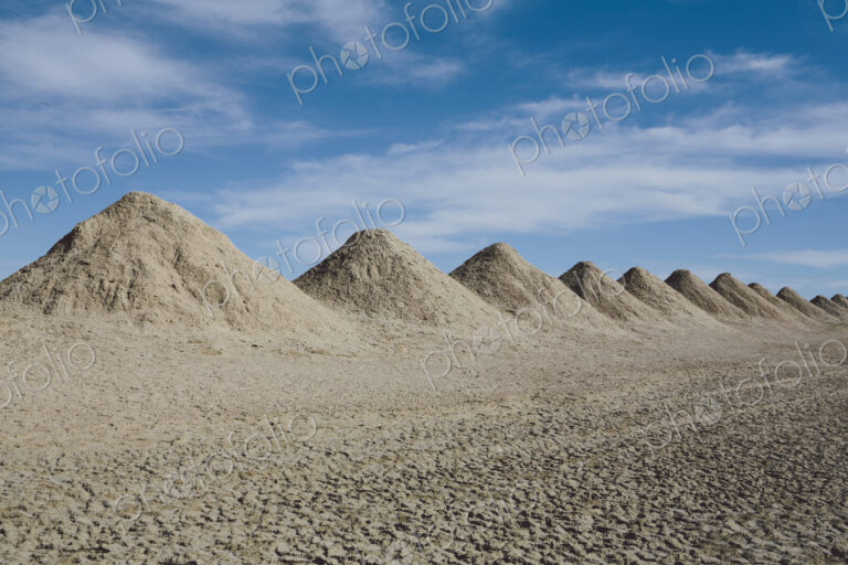 Mining tailings creating row of dirt piles in a desert, extraction