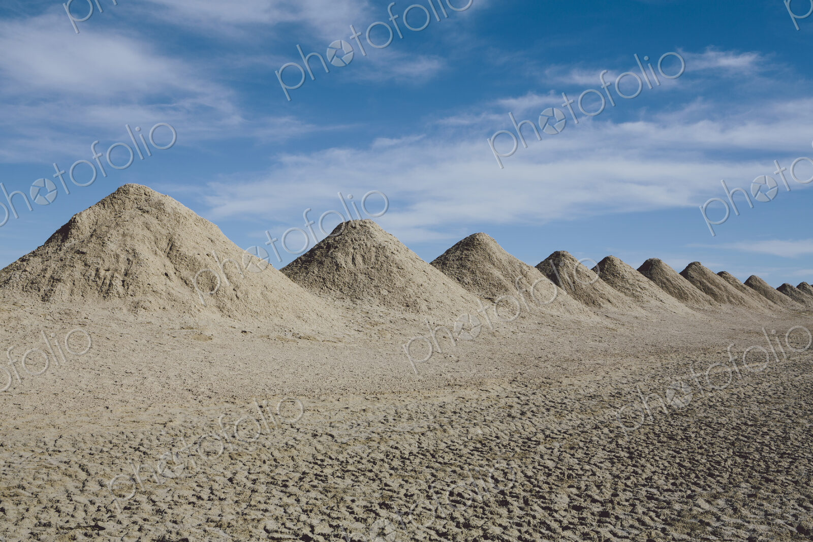 Mining tailings creating row of dirt piles in a desert, extraction