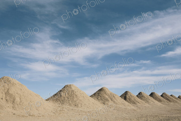 Mining tailings creating row of dirt piles in a desert, mine extraction.