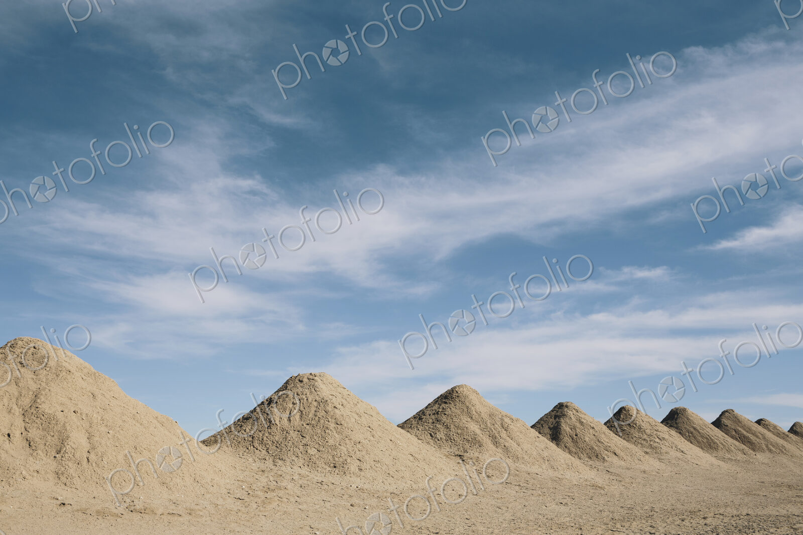 Mining tailings creating row of dirt piles in a desert, mine extraction.