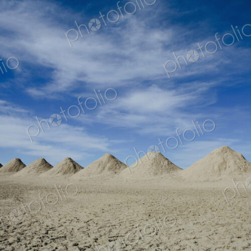 Mining tailings creating row of dirt piles in desert Mining tailings creating row of dirt piles in desert