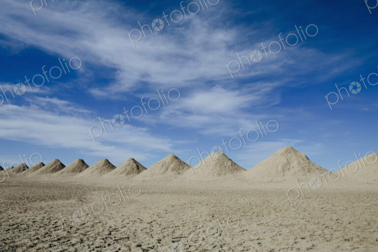 Mining tailings creating row of dirt piles in desert