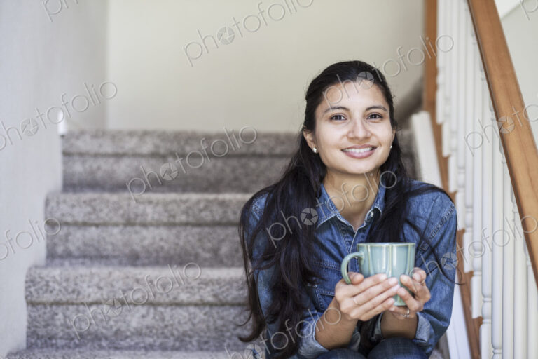 Mixed race caucasian woman with a cup of coffee at home.
