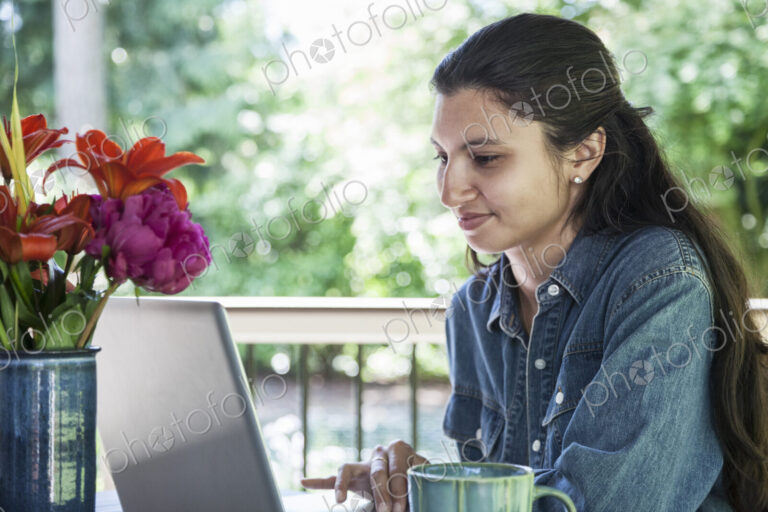 Mixed race caucasian woman working on a laptop at home.