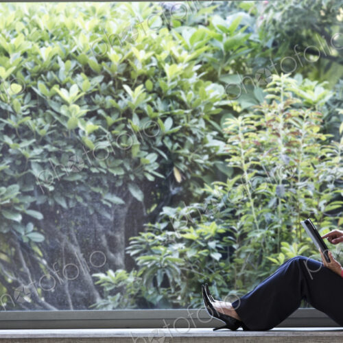 Mixed race caucasian woman working on a laptop computer in a business center lobby.