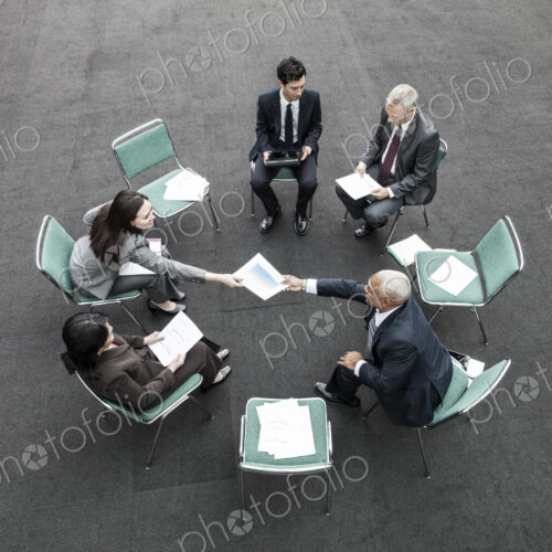 Mixed race group of business people in an informal team building meeting. Mixed race group of business people in an informal team building meeting.