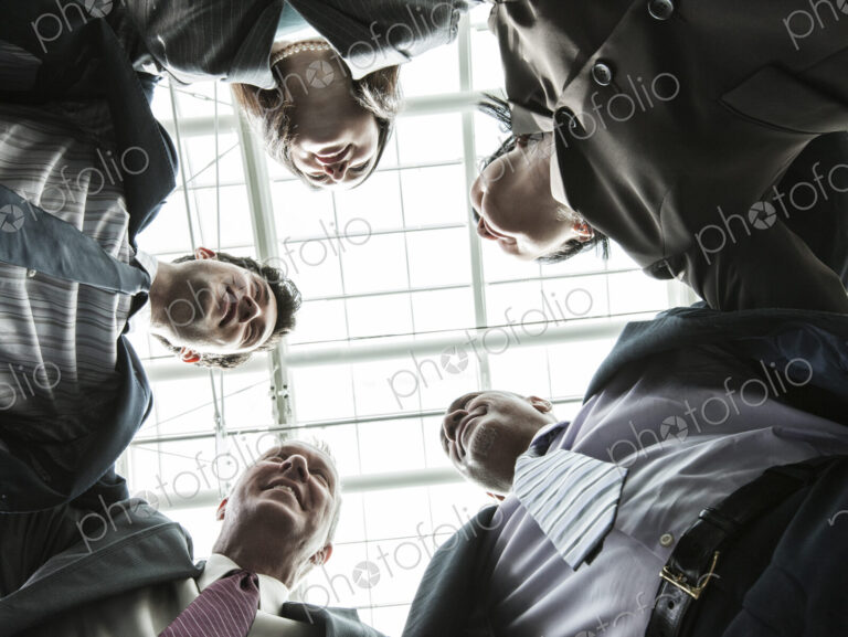 Mixed race group of business people standing in a team building circle.