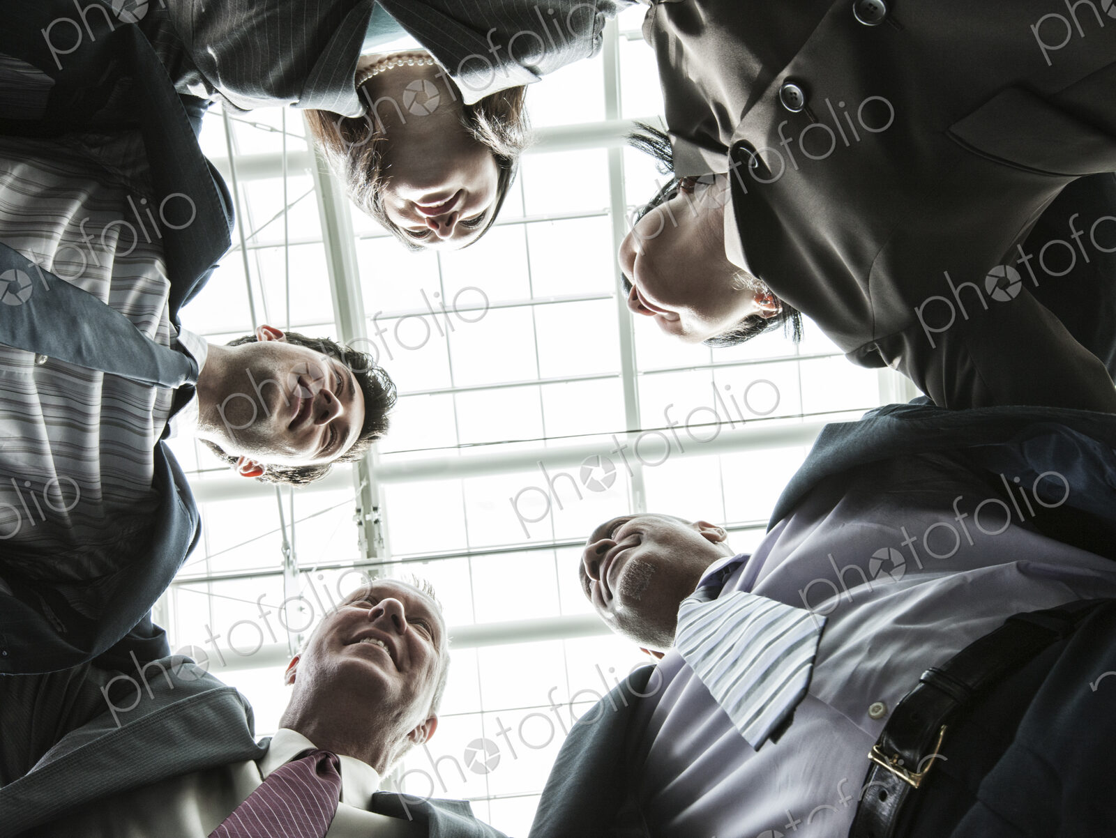 Mixed race group of business people standing in a team building circle.