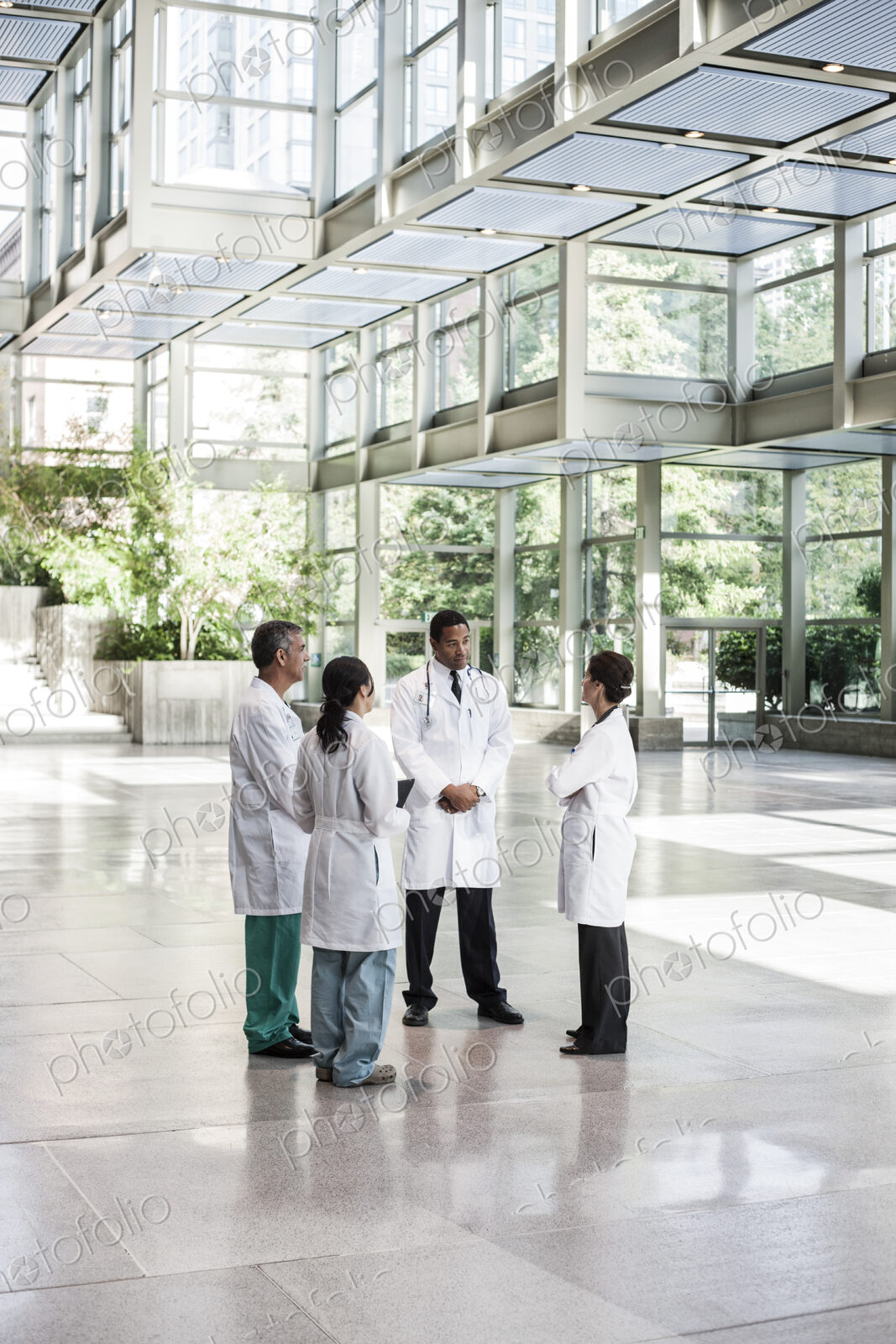 Mixed race group of doctors meeting in lobby of large hospital