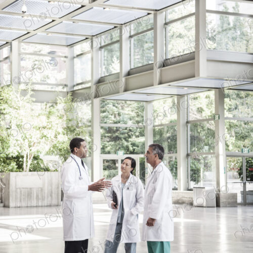 Mixed race group of doctors meeting in lobby of large hospital Mixed race group of doctors meeting in lobby of large hospital