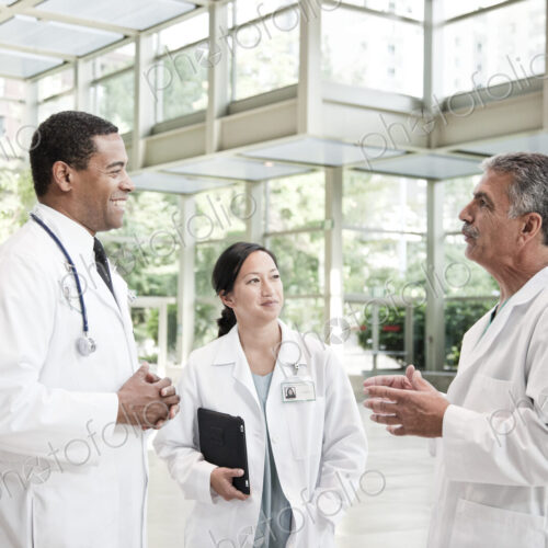 Mixed race group of doctors meeting in lobby of large hospital Mixed race group of doctors meeting in lobby of large hospital