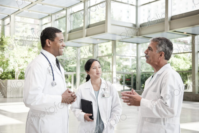Mixed race group of doctors meeting in lobby of large hospital