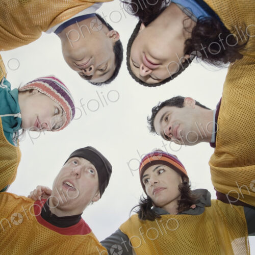 Mixed race group of men and women in a hudddle for an outdoor sporting event. Mixed race group of men and women in a hudddle for an outdoor sporting event.