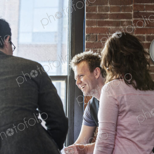 Mixed race group of people meeting to brainstorm an issue in a creative office.