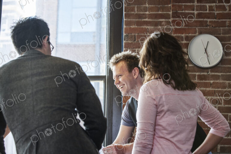 Mixed race group of people meeting to brainstorm an issue in a creative office.