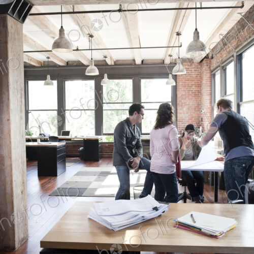 Mixed race group of people meeting to brainstorm an issue in a creative office.