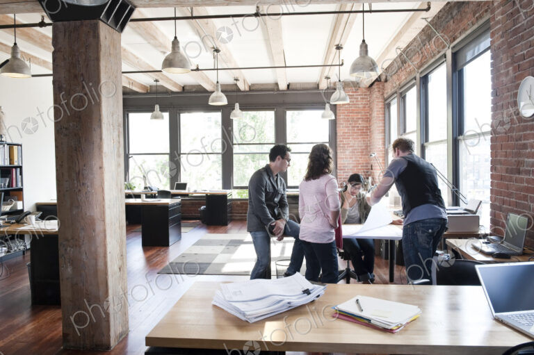 Mixed race group of people meeting to brainstorm an issue in a creative office.