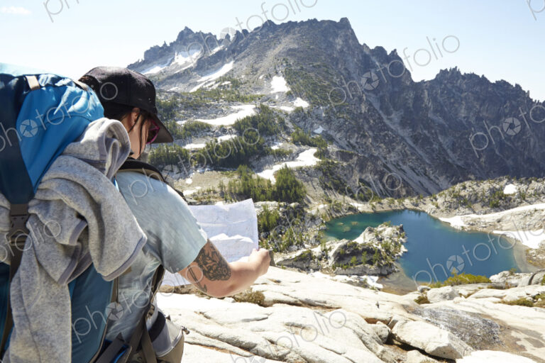 Mixed race man reading map on hilltop