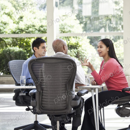 Mixed race team of business people at a table in a business center. Mixed race team of business people at a table in a business center.