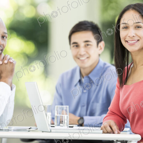 Mixed race team of business people at a table in a business center. Mixed race team of business people at a table in a business center.