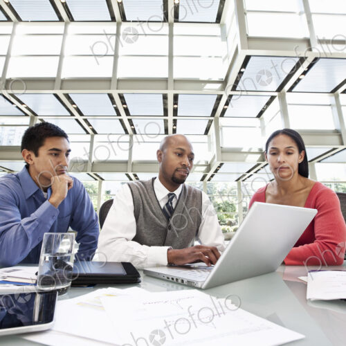 Mixed race team of business people at a table in a business center. Mixed race team of business people at a table in a business center.