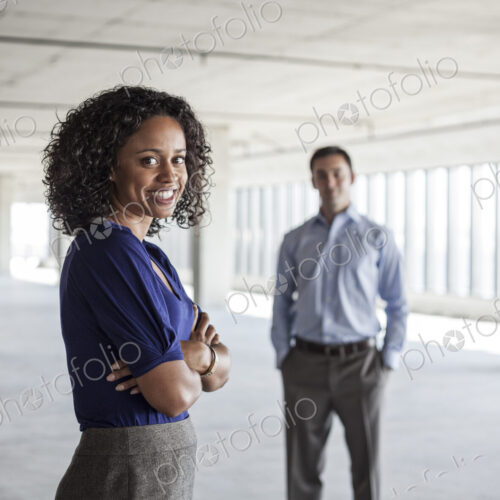 Mixed race team of business people in a large empty raw office space. Mixed race team of business people in a large empty raw office space.