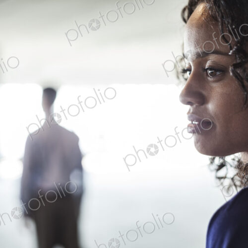 Mixed race team of business people in a large empty raw office space.