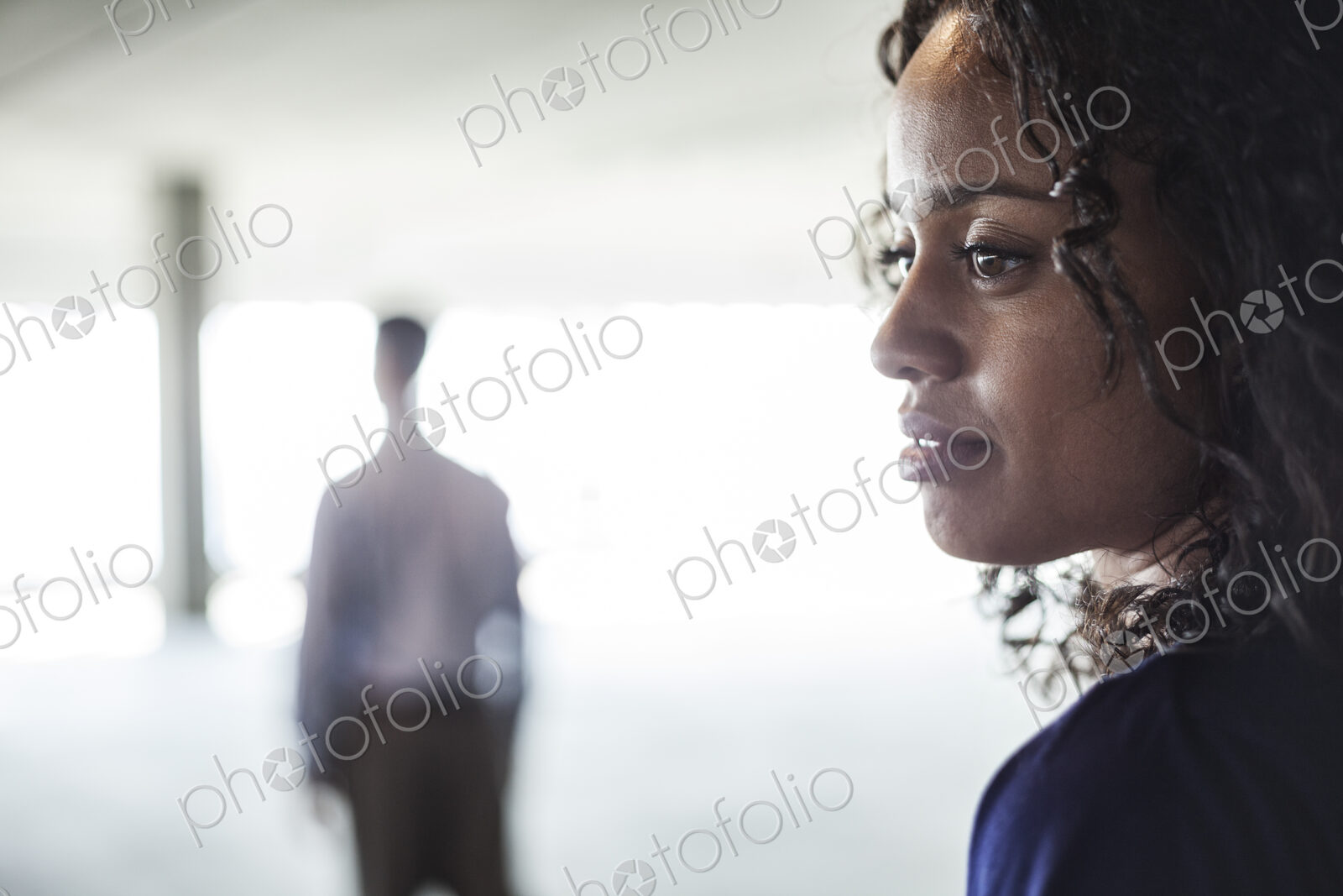 Mixed race team of business people in a large empty raw office space.