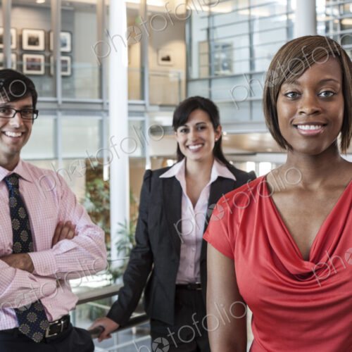 Mixed race team of business people in the lobby of a large office building. Mixed race team of business people in the lobby of a large office building.
